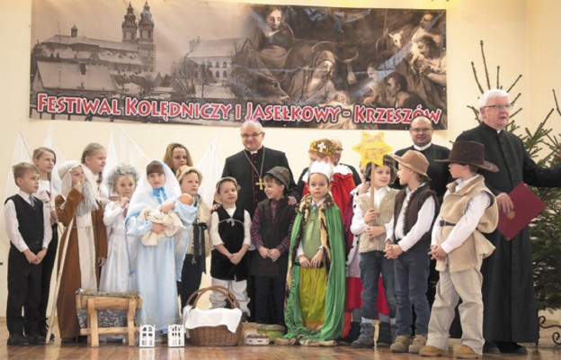 Bp Marek Mendyk, o. Piotr Dettlaff i ks. Marian Kopko wraz z dziećmi, które uświetniły spotkanie przedstawieniem jasełek