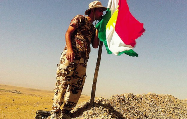 Żołnierz kurdyjski – peszmerg oddający hołd fl adze Kurdystanu