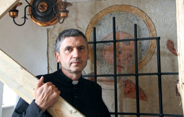 Ks. Piotr Matus na tle XiV-wiecznego malowidła przedstawiającego św. Piotra