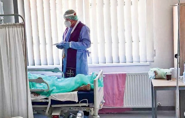 Kapelan z modlitwą przy łóżku osoby chorej na koronowirusa