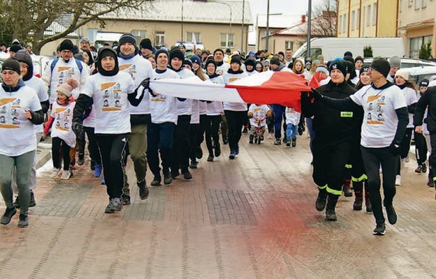 Uczestnicy biegu nieśli ze sobą biało-czerwoną flagę