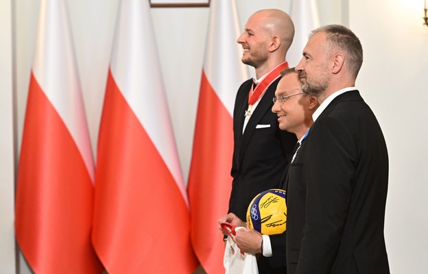 Prezydent Andrzej Duda (C) pozuje do zdjęcia z siatkarzem reprezentacji Polski Bartoszem Kurkiem (P) i trenerem kadry siatkarzy Nikolą Grbiciem (przód)