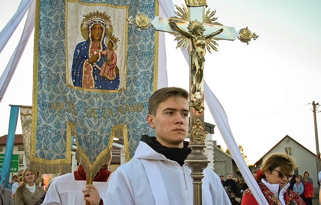 Na czele procesji krzyż i sztandar z wizerunkiem Matki Bożej