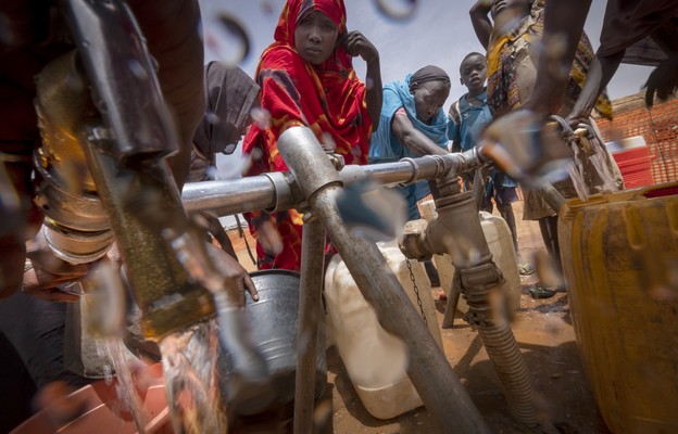 Sudańscy uchodźcy czerpią wodę ze studni w obozie przejściowym Adre na granicy z Sudanem.