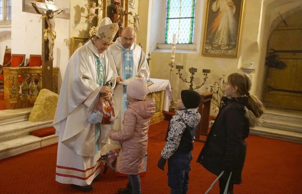 Bp Adam Bałabuch i ks. kan. Grzegorz Góra wręczają podarki dzieciom z Bolesławowa