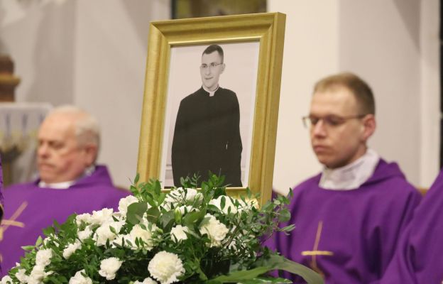 Portret śp. ks. Sebastiana Makucha w otoczeniu białych kwiatów. Fotografia umieszczona w kościele Niepokalanego Poczęcia NMP w Wałbrzychu podczas Mszy św. żałobnej.